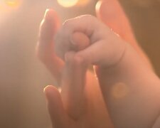 Мама держит за руку ребенка: скрин с видео