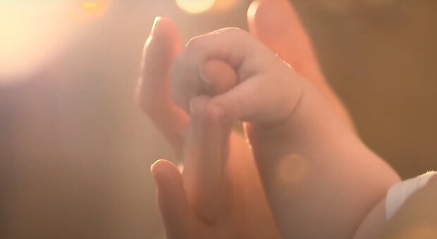 Мама держит за руку ребенка: скрин с видео